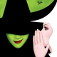 Glinda the Good Witch in white whispers to the smirking, green-skinned Wicked Witch of the West